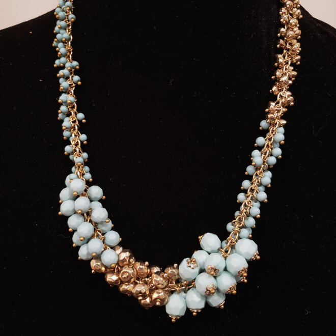 Contemporary asymmetrical gold tone and light blue bead costume jewelry necklace.
