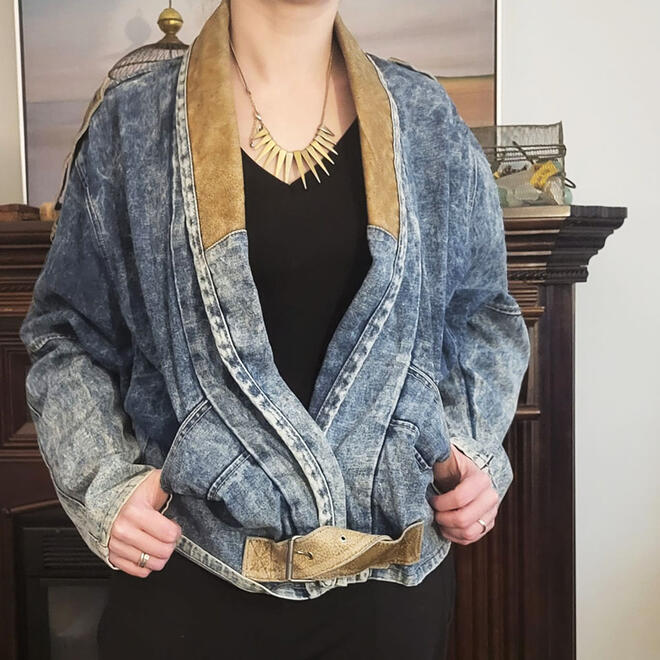Cecilia posing in a vintage Bianca Nygard denim jacket with a black t-shirt and bronze spikey necklace.